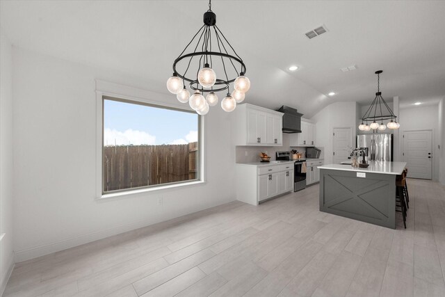 kitchen featuring stainless steel appliances, a center island with sink, a breakfast bar, custom exhaust hood, and white cabinetry