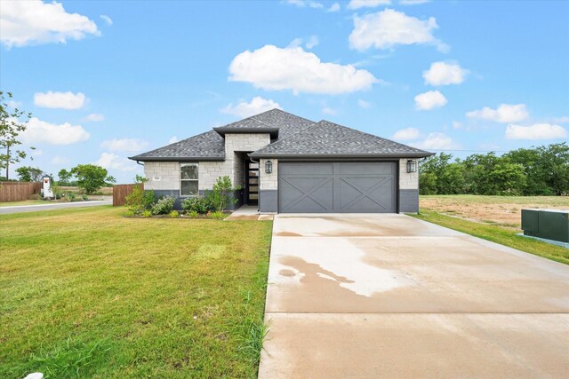 view of front of house featuring a garage and a front lawn