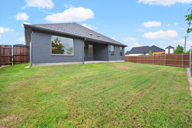 rear view of property with a patio and a lawn