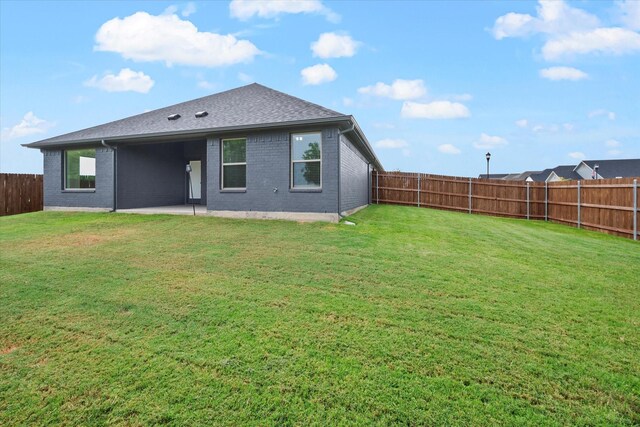 back of house with a patio and a lawn