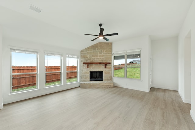 unfurnished living room featuring lofted ceiling, light hardwood / wood-style floors, a fireplace, and ceiling fan