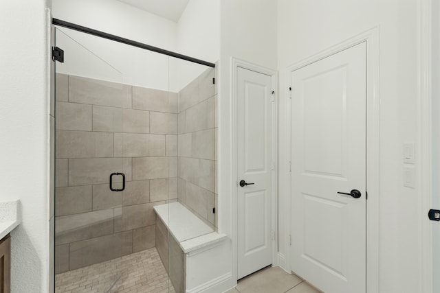 bathroom featuring walk in shower, vanity, and tile patterned floors