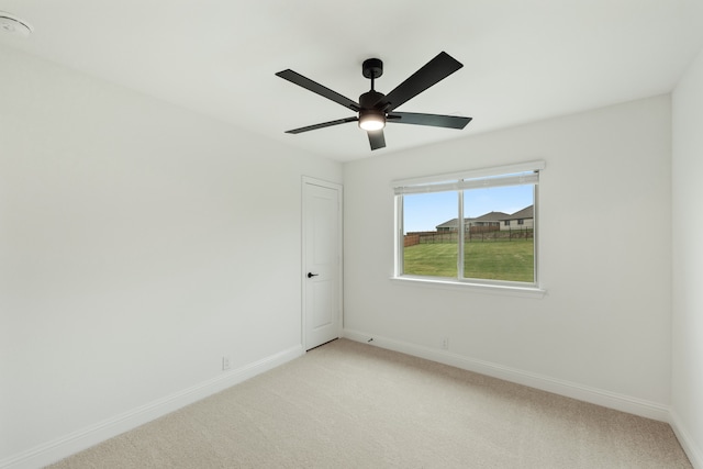 carpeted empty room featuring ceiling fan