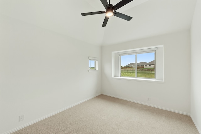 empty room featuring lofted ceiling, ceiling fan, and carpet floors