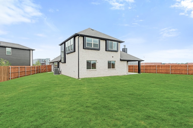 rear view of property featuring a yard and central air condition unit