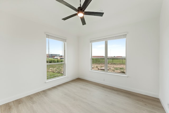 unfurnished room featuring ceiling fan, light wood-type flooring, and plenty of natural light