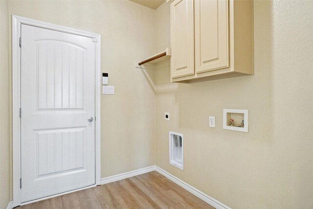 clothes washing area featuring cabinets, hookup for a washing machine, hookup for an electric dryer, and light wood-type flooring