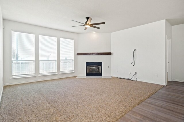 unfurnished living room featuring carpet and ceiling fan