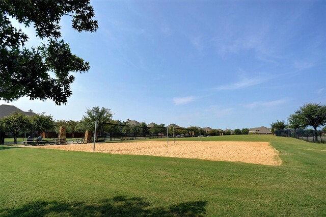 view of community with volleyball court and a lawn