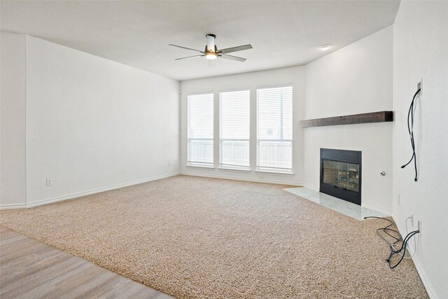 unfurnished living room featuring ceiling fan and light colored carpet