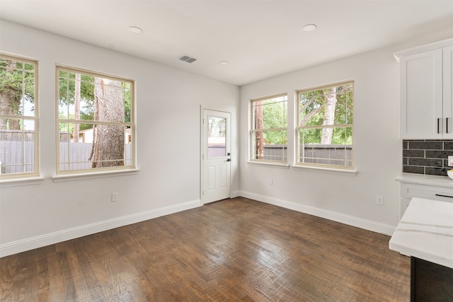 unfurnished dining area with dark wood-type flooring and a healthy amount of sunlight