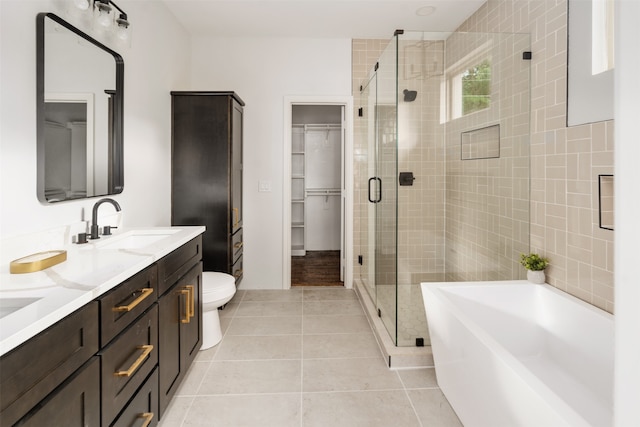 full bathroom with tile patterned floors, separate shower and tub, vanity, and toilet