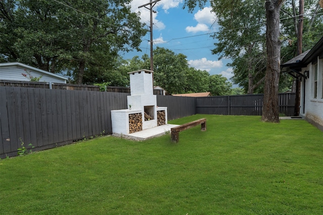 view of yard with an outdoor brick fireplace