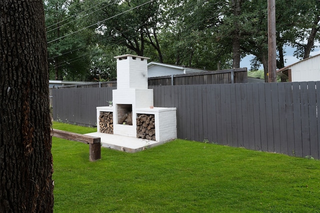 view of yard with an outdoor fireplace