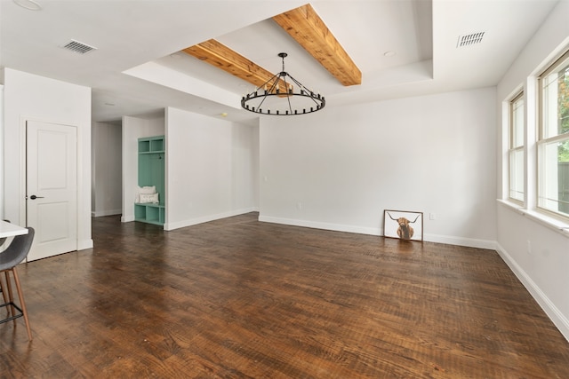 empty room with beam ceiling, dark wood-type flooring, and a raised ceiling