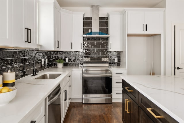 kitchen with appliances with stainless steel finishes, wall chimney exhaust hood, light stone countertops, sink, and white cabinetry