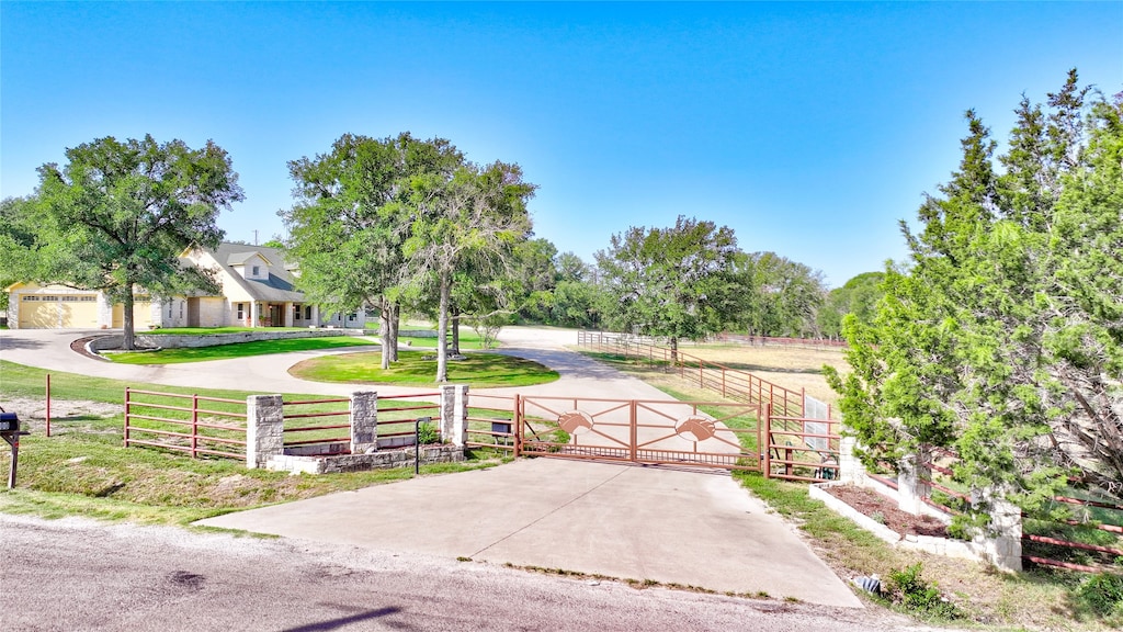 view of front of home with a rural view and a front yard