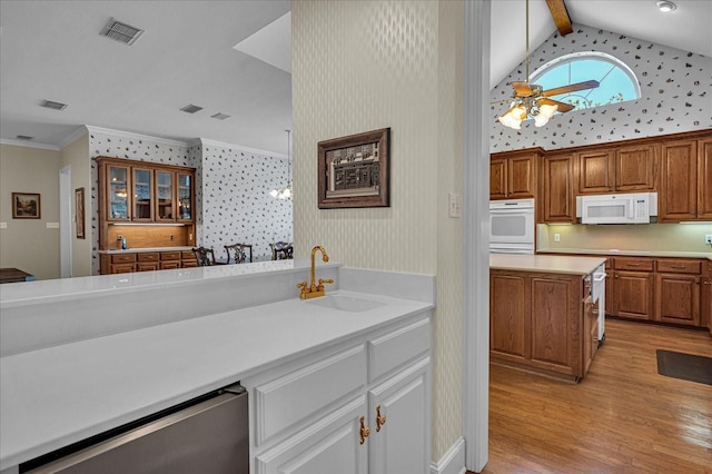 kitchen with lofted ceiling with beams, sink, ceiling fan, crown molding, and light wood-type flooring