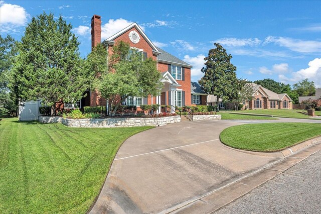 colonial inspired home with a front lawn