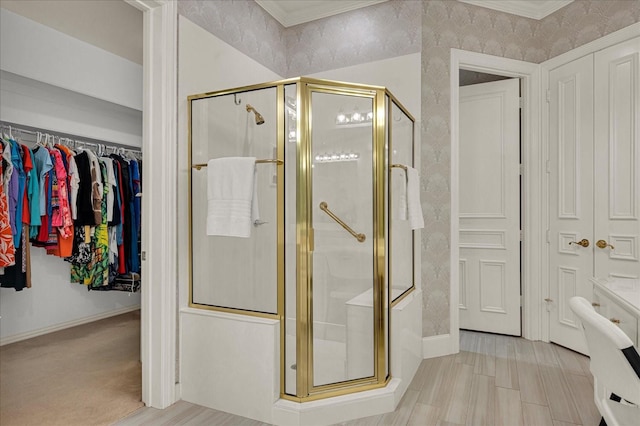 bathroom featuring crown molding and a shower with door