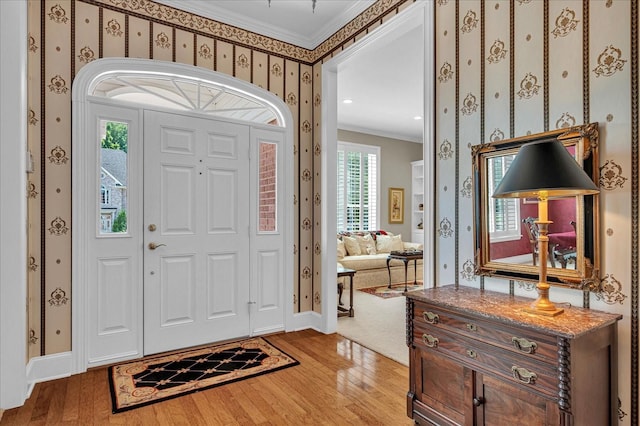 entrance foyer with crown molding and light hardwood / wood-style floors