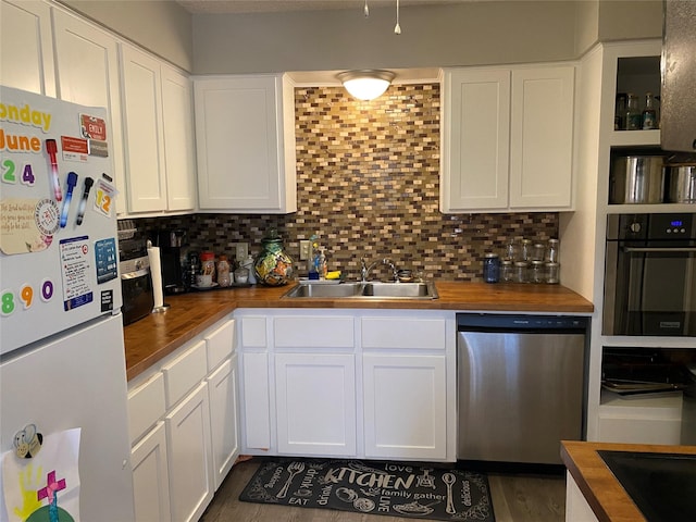 kitchen featuring wood counters, sink, white cabinetry, appliances with stainless steel finishes, and backsplash