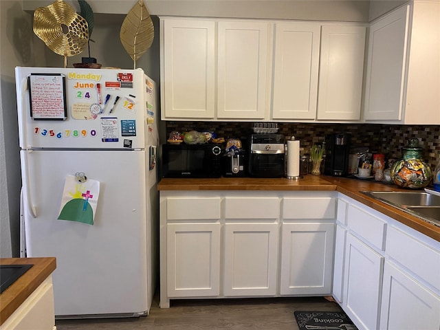 kitchen with white cabinetry, tasteful backsplash, and black appliances