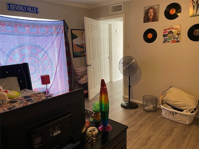 bedroom with crown molding and hardwood / wood-style floors