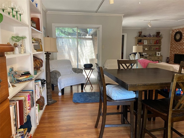 dining area with crown molding and light hardwood / wood-style flooring