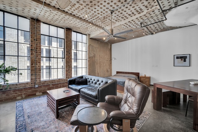 living room featuring concrete flooring, ceiling fan, and a wall of windows