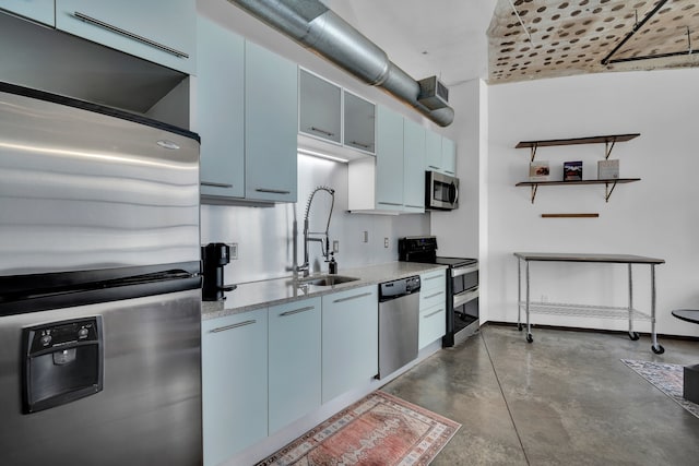 kitchen with sink, blue cabinets, stainless steel appliances, and concrete floors