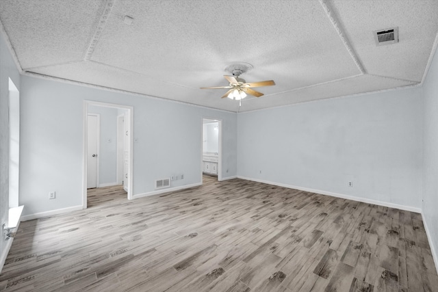 interior space with a textured ceiling, lofted ceiling, ceiling fan, and light wood-type flooring