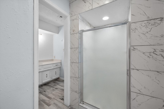 bathroom with vanity, hardwood / wood-style floors, and a shower with shower door