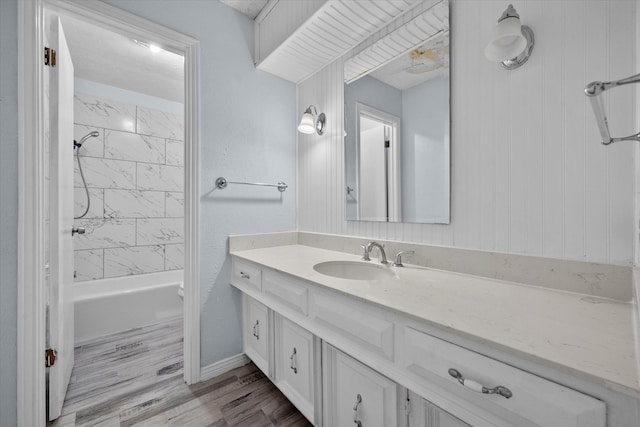 bathroom featuring vanity, wood-type flooring, and tiled shower / bath