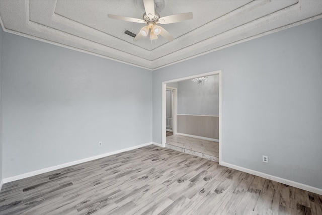 spare room featuring wood-type flooring, a raised ceiling, and ceiling fan