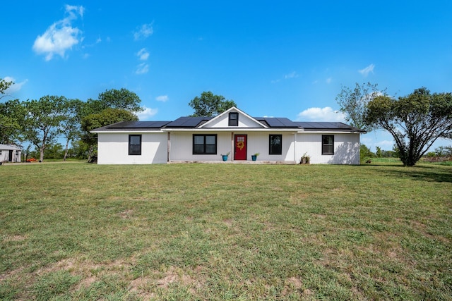 view of front of property featuring a front lawn and solar panels