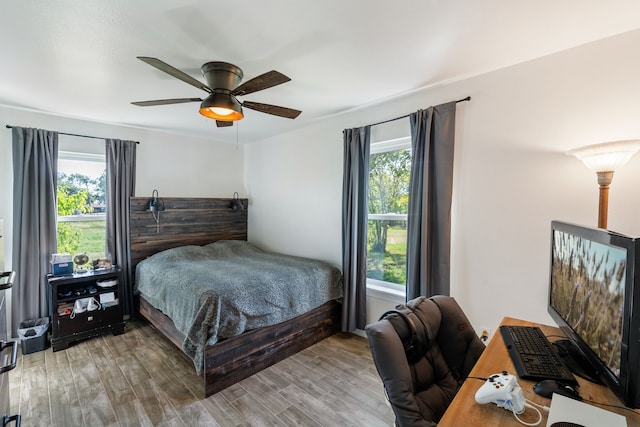 bedroom featuring hardwood / wood-style flooring, multiple windows, and ceiling fan