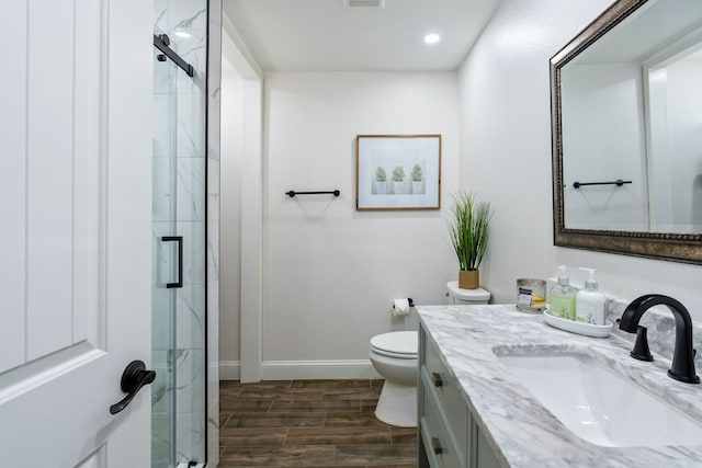 bathroom with vanity, an enclosed shower, hardwood / wood-style flooring, and toilet