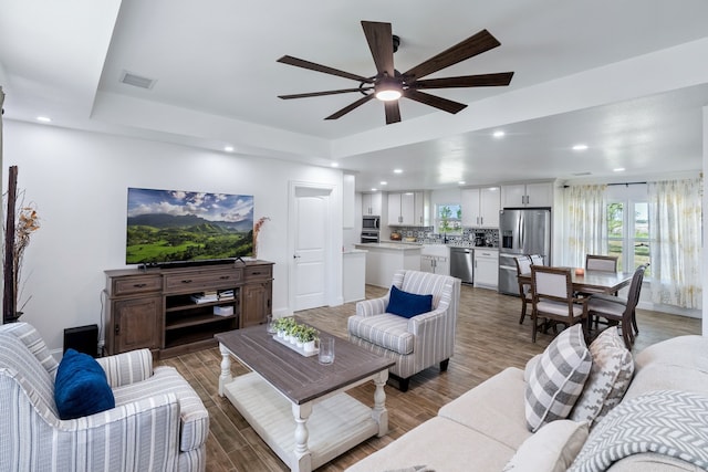 living room with ceiling fan and hardwood / wood-style flooring