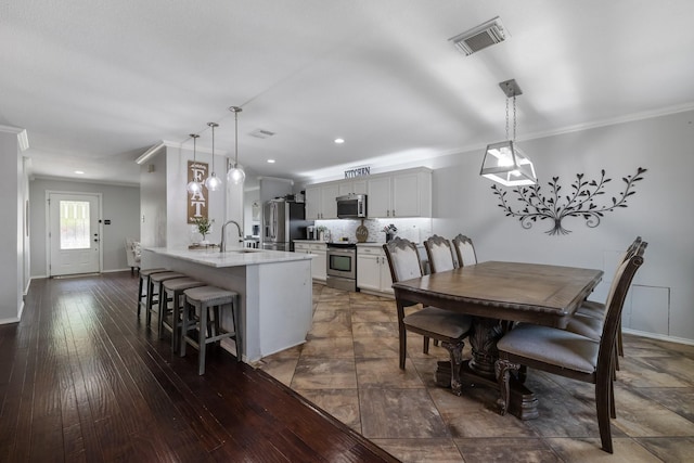 dining room featuring ornamental molding, dark hardwood / wood-style flooring, and sink