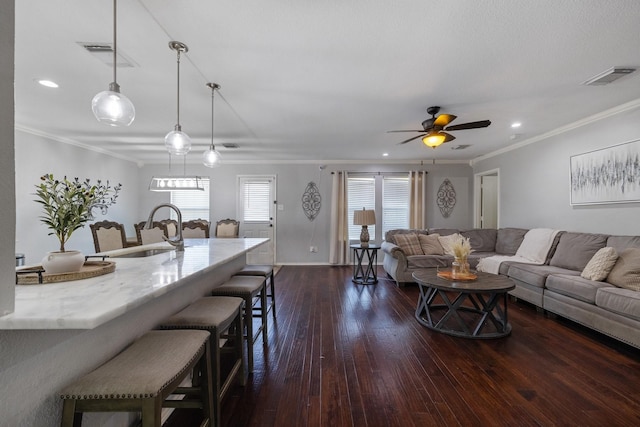 living room with crown molding, sink, dark wood-type flooring, and ceiling fan