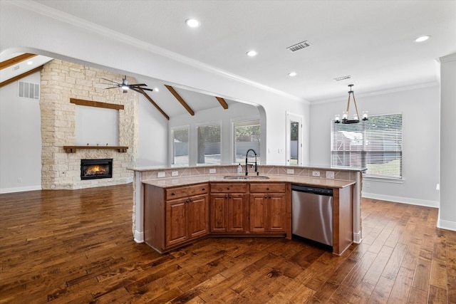 kitchen with a fireplace, dark hardwood / wood-style flooring, sink, and stainless steel dishwasher