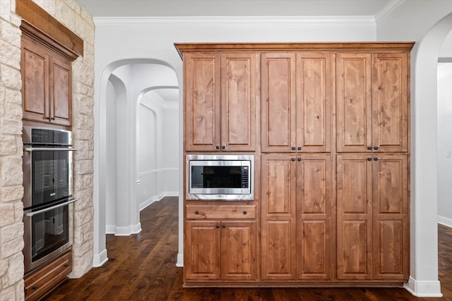 kitchen featuring appliances with stainless steel finishes, dark hardwood / wood-style floors, and crown molding