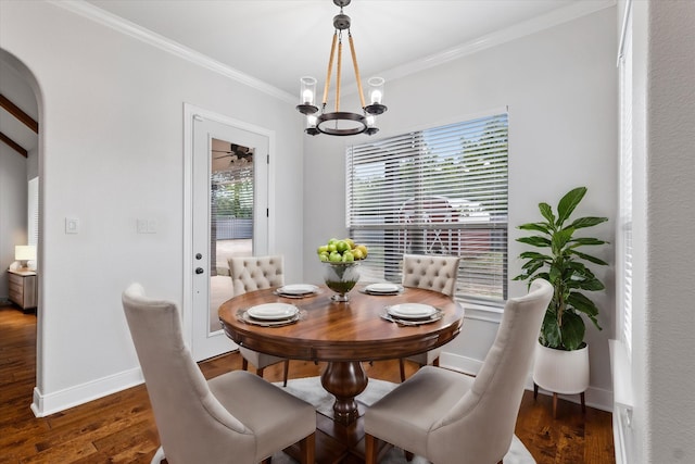 dining area with ornamental molding, dark hardwood / wood-style flooring, and an inviting chandelier