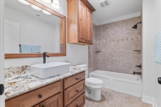 full bathroom featuring vanity, tiled shower / bath, tile patterned floors, and toilet