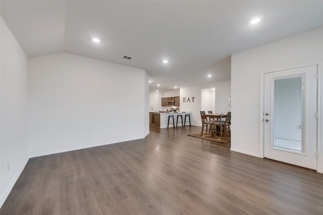 unfurnished living room with dark hardwood / wood-style floors and vaulted ceiling