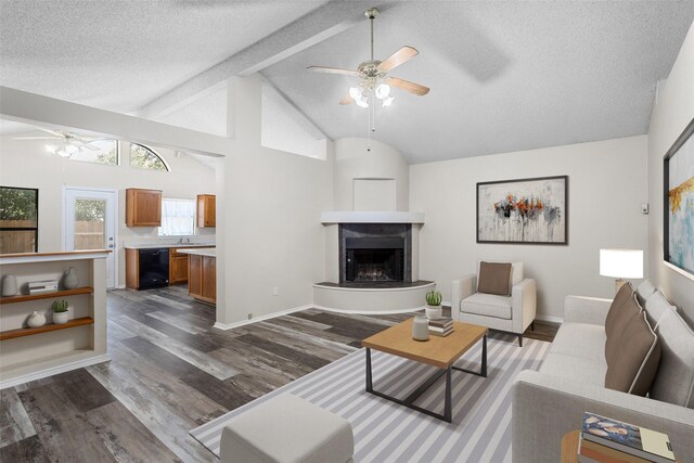 living room featuring vaulted ceiling with beams, a textured ceiling, ceiling fan, and hardwood / wood-style floors