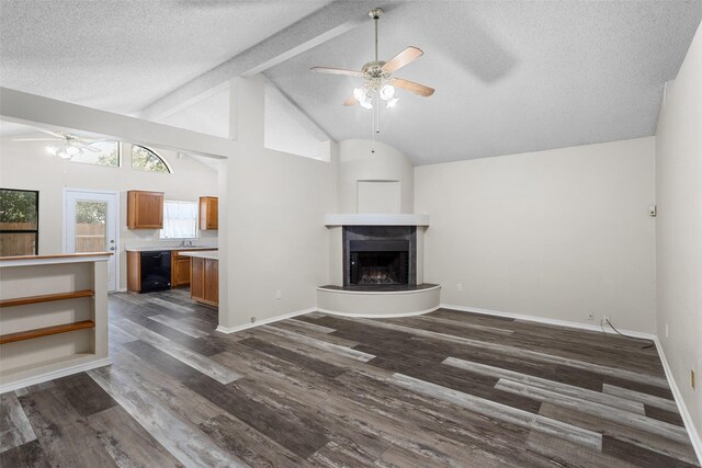 unfurnished living room with beam ceiling, a textured ceiling, dark hardwood / wood-style flooring, ceiling fan, and high vaulted ceiling