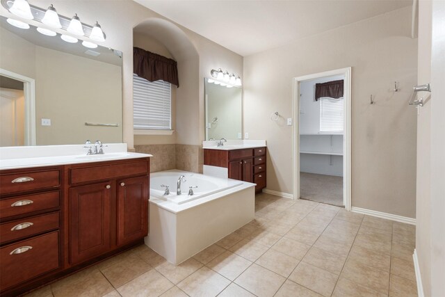 bathroom with tile patterned floors, vanity, and a bath