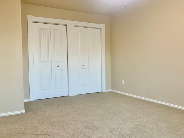 unfurnished bedroom with light colored carpet and multiple closets